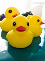 portrait of a rubber toy duck floating on a fluid art picture. yellow floating bird for games with children and adults. decoration for the bathroom photo