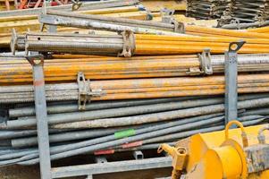 A lot of building materials with metal spare parts, sticks, beams, pipes at an open-air construction site warehouse photo