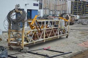 Large iron metal building facade elevator cradle for lifting workers and a load of building materials during the repair of the external facade and painting of the building photo