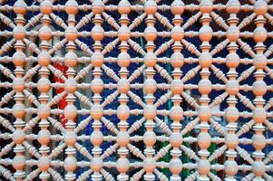 Texture of a wooden brown grating with holes on the window in Arabic style. The background photo