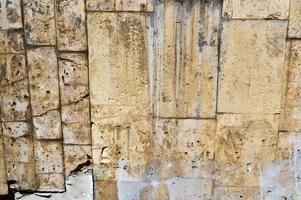 Texture of old shabby stone yellow porous bricks vertical rectangular. The background photo