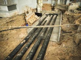 construction of a new neighborhood in the city. black long pipes are laid underground for communications. sewerage in houses photo