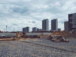 construcción de un nuevo barrio en la ciudad. casas altas hechas de vidrio, hormigón y con ventanas panorámicas. grava pequeña para el tendido de carreteras y comunicaciones foto