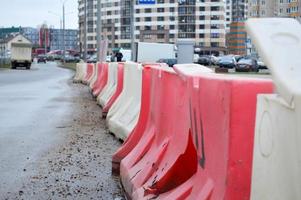 grandes bloques de plástico rojo y blanco llenos de agua para la seguridad vial durante la reparación de carreteras foto