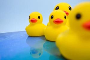 A bright yellow toy duck for swimming with children floats on the water in the ocean. duck with ducklings floats on the water surface. abstract background photo