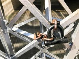 Iron gates, metal bar fence frozen on a strong old rusty chain of links on a granary large lock. The background photo