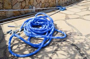 Blue plastic long large corrugated hose for cleaning the pool wash and watering the plants photo