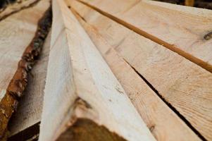 Lots of long wooden natural planed boards and sticks at a sawmill. The background. Texture. Concept timber harvesting for the wood industry photo