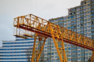 High heavy yellow metal iron load-bearing construction stationary industrial powerful gantry crane of bridge type on supports for lifting cargo on a modern construction site of buildings and houses photo