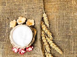 Wheat spikelets of straw and salt shaker with salt on an old brown rough canvas, tablecloth. Slavic symbol of welcome bread and salt. The background. Texture photo