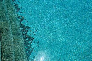 la textura de la entrada de la bajada a la piscina con agua azul y baldosas cerámicas cuadradas en los escalones. el fondo foto