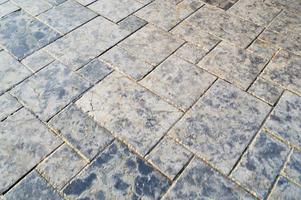 Texture of a stone wall, roads from stones, bricks, cobblestones, tiles with sandy seams of gray ancient natural old yellow with sharp edges. The background photo