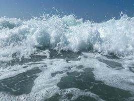 hermoso mar con olas salpicando cálidas y brillantes aguas azules en un cálido resort tropical oriental del sur. fondo, textura foto