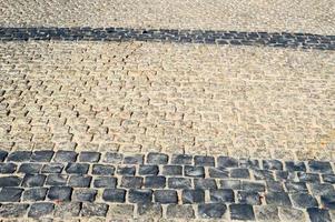 Texture of a stone wall, roads from stones, bricks, cobblestones, tiles with sandy seams of gray ancient natural old yellow with sharp edges. The background photo