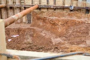 A large huge ditch pit tunnel with reinforcing structures from thick iron pipes of beams and structures at the construction site of the underground metro station line photo