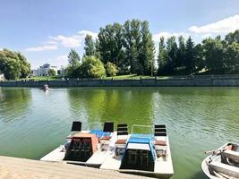 botes y catamaranes en un lago estanque en un canal fluvial con agua de flores verdes están amarrados en la orilla foto