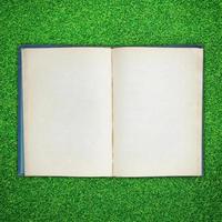 Old book open on green grass background photo