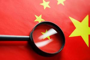 The flag of the CHINESE PEOPLE'S REPUBLIC is looking through a magnifying glass. The study of the history and culture of a large country and the people of China. The concept of studying the geography photo