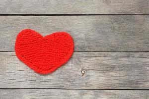 Red knitted heart on a gray wooden background, symbolizing love photo