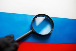 The flag of the Russian Federation looks through a magnifying glass. The study of the history and culture of the people of a large country of Russia. The concept of studying geography photo