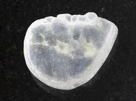 tumbled Ulexite gemstone on dark background photo