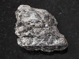 rough quartz-biotite schist stone on dark photo