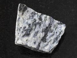 raw migmatite stone on dark background photo