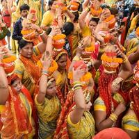 New Delhi, India April 03 2022 - Women with Kalash on head during Jagannath Temple Mangal Kalash Yatra, Indian Hindu devotees carry earthen pots containing sacred water with a coconut on top photo