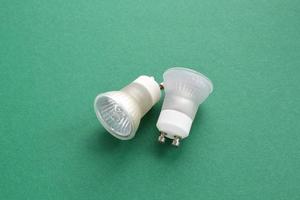 Electric LED light bulbs lamp on green background with copy space. Eco saving power and environmental conservation energy efficiency concept. Ecological friendly and sustainable lifestyle. Flat lay photo