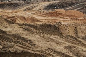 Tire track mark lines shape on dry sand background. Trail tyre imprint from heavy machinery. Vehicle shape. Road construction site backdrop concept. Trace of wheel pattern on mud. Nature texture. photo