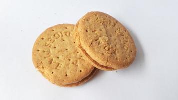 BISCUITS - Delicious wheat round biscuits with a few crumbs isolated on white photo