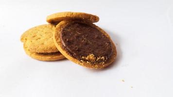 una pila de deliciosas galletas redondas de trigo con relleno de chocolate aisladas en fondo blanco foto