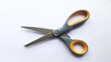 Used orange and grey scissors on a white background photo