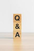 Questions and Ask word with wood block on table background. FAQ, frequency asked questions, Answer, Q and A, Information, Communication, questionnaire and Brainstorming Concepts photo