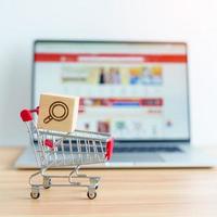 Shopping cart with Magnifying icon block and laptop computer with marketplace website, technology, ecommerce, SEO, Search Engine Optimization, Advertising, keyword and online payment concept photo