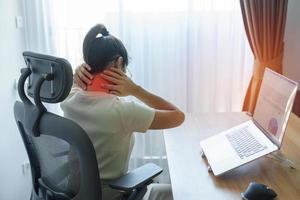 Woman having Neck and Shoulder pain during work long time on workplace. due to fibromyalgia, rheumatism, Scapular pain, office syndrome and ergonomic concept photo