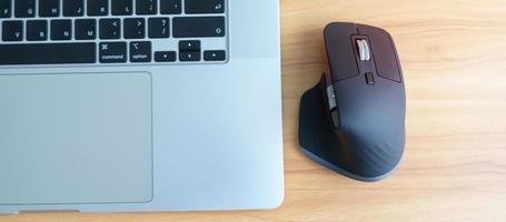 Ergonomic vertical mouse with laptop computer on adjustable desk at workplace, prevention wrist pain. De Quervain s tenosynovitis, Intersection Symptom, Carpal Tunnel or Office syndrome concept photo