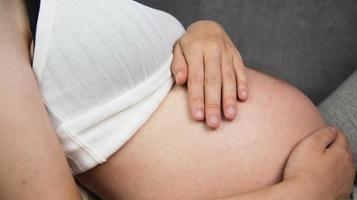 pregnant woman holding her stomach photo