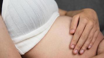 pregnant woman holding her stomach photo