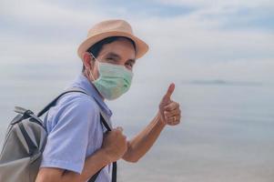 People wear medical mask thump up travel on beach safety covid19 photo