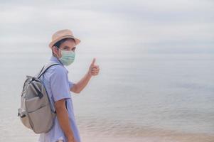 People wear medical mask thump up travel on beach safety covid19 photo