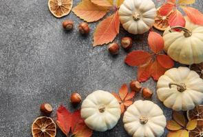 Autumn leaves and pumpkins over  grey concrete background