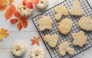 Autumn baking. Cookies in the form of pumpkin and leaves on the table. photo