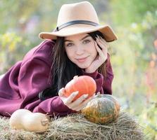 niña feliz con calabaza en el jardín de otoño foto