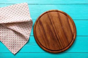 Frame of cutting board on polka dots tablecloth. Blue wooden background in the cafe. copy space photo