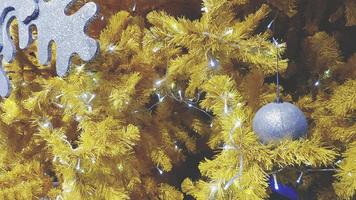 bola plateada e iluminación blanca decorada en pino amarillo en tono vintage. feliz año nuevo, navidad y concepto de festival de invierno foto