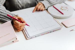 mujer planeando su semana en el calendario foto