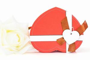 Close up white rose and heart shaped box on white photo