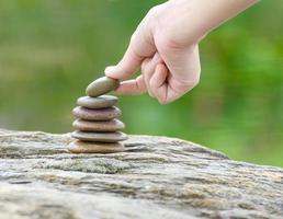 Hand put stone building a pile of zen stones photo