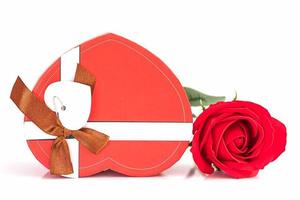 Close up red rose and heart-shaped box on white photo